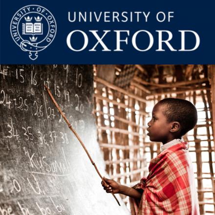 Small boy pointing at black board with a stick